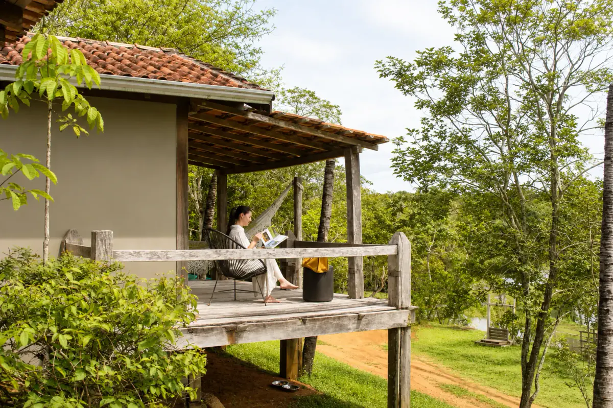 A guest reading on the veranda of Jardim da Amazônia, surrounded by forest